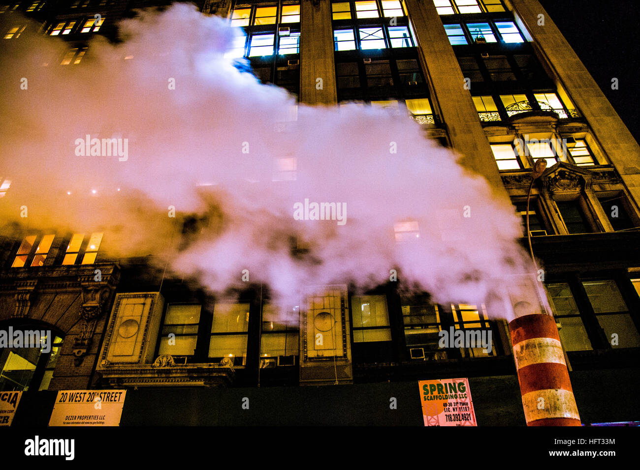 La fumée s'élevant dans le ciel de nuit dans une rue de Manhattan Banque D'Images