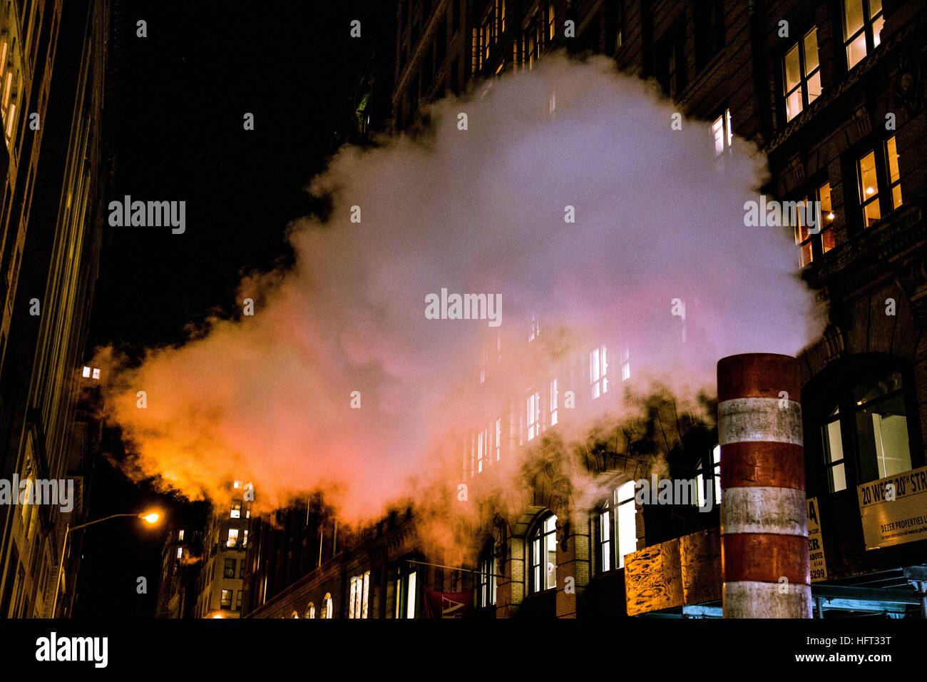 La fumée s'élevant dans le ciel de nuit dans une rue de Manhattan Banque D'Images