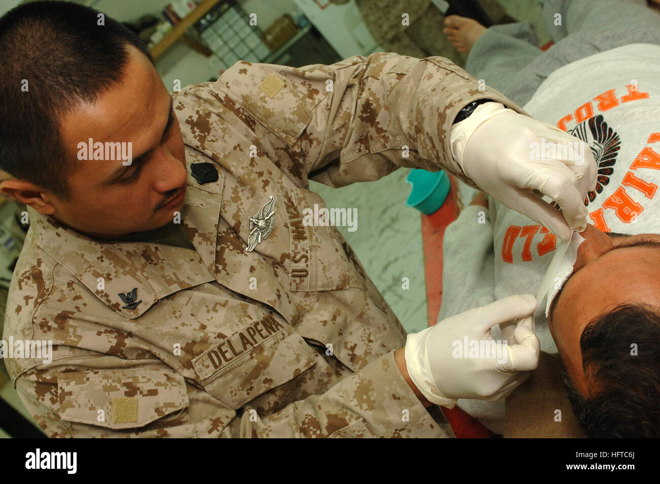 061220-N-5758H-086 Al Asad, l'Iraq (31 déc. 20, 2006) - 3e classe Corpsman Hôpital Delapena Aloen, affecté à la 1e Bataillon Médical, Camp Pendleton, bandages propres s'applique à une blessure à la face d'un citoyen irakien. Le 1er Bataillon Médical Camp Pendleton offre des soins de niveau II, ce qui est de la Réanimation chirurgicale de forces armées américaines, les forces de la coalition, les forces de sécurité irakiennes et des civils à l'appui de la guerre globale contre le terrorisme. U.S. Navy photo by Mass Communication Specialist Seaman Kenneth R. Hendrix (libéré) US Navy 061220-N-5758H-086 Hospital Corpsman 3rd Class Aloen Delapena attribué, t Banque D'Images