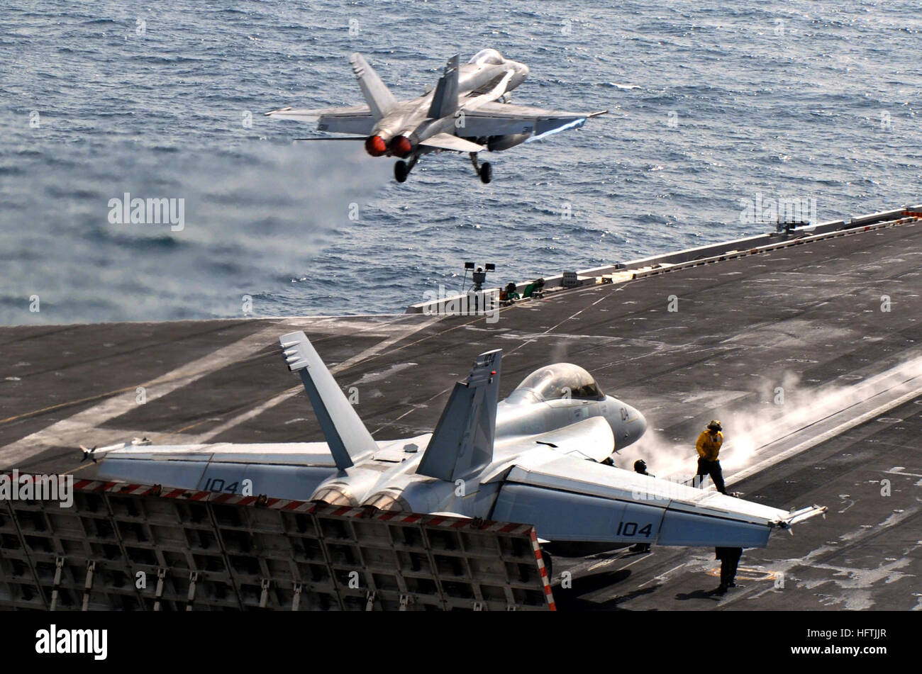 070328-N-7780S-052 DU GOLFE PERSIQUE (28 mars 2007) - Un F/A-18C Hornet, affecté à la 'Blue Diamonds' de Strike Fighter Squadron (VFA) 146, lance au poste de pilotage qu'un F/A-18F Super Hornet, affecté à la 'Black Knights' de Strike Fighter Squadron (VFA) 154, se prépare à lancer à partir de la catapulte à bord des deux porte-avions de classe Nimitz USS JOHN C. STENNIS (CVN 74). John C. Stennis et Groupe Carrier Air Wing 9 (CVW) mènent un double-transporteur exercice avec Eisenhower et Groupe aéronaval Carrier Air Wing (CVW) 7. C'est la première fois que le Stennis et Eisenhower st Banque D'Images