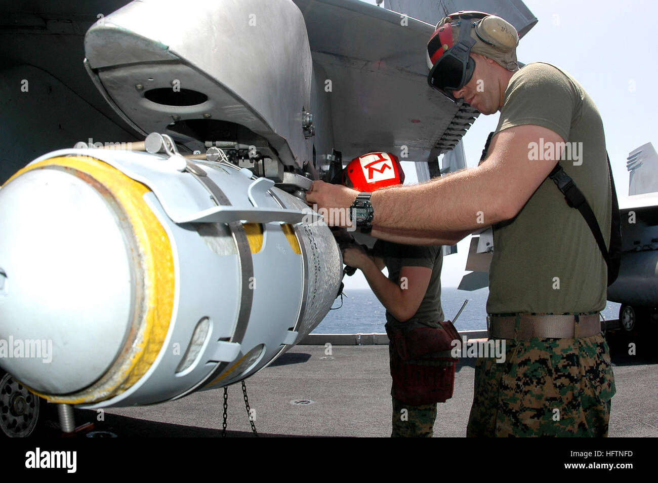 070508-N-9760Z-005 de l'OCÉAN PACIFIQUE (8 mai 2007) - lance le Cpl. Ryan Adair, affecté à la 'Red Devils' of Marine Fighter Attack Squadron (VMFA) 232, charge une bombe GBU-38 sur un F/A-18B Hornet à bord du porte-avions à propulsion nucléaire USS Nimitz (CVN 68). Groupe aéronaval du Nimitz et entrepris Carrier Air Wing (CVW) 11 mènent des opérations de sécurité maritime (ASM). U.S. Navy photo by Mass Communication Specialist Seaman Eduardo Saragosse (publié) US Navy 070509-N-9760Z-005 Lance Cpl. Ryan Adair, affecté à la Red Devils of Marine Fighter Attack Squadron (VMFA) 232, charge une bombe GBU-38 sur Banque D'Images