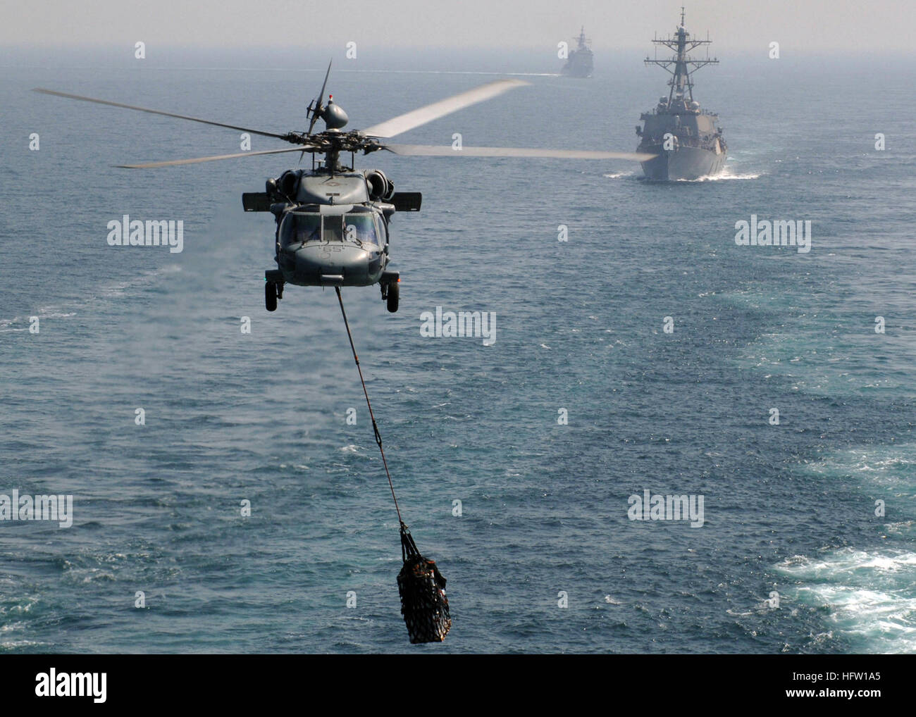 071004-N-5928K-006 GOLFE PERSIQUE (oct. 4, 2007) - Un MH-60S Seahawk, attaché à la "mer des Chargers hélicoptère de combat de l'Escadron (HSC) transporte 26 Fournitures à des porte-avions USS Enterprise (CVN 65), tandis que les missiles guidés destroyer USS Arleigh Burke (DDG 51)-missiles et cruiser USS Vicksburg (CG 69) suivre derrière. Les entreprises et l'entrepris Carrier Air Wing 1 (CVW) sont en cours sur un déploiement prévu. U.S. Navy photo by Mass Communication Specialist 3rd Class N.C. Kaylor (libéré) US Navy 071004-N-5928K-006 un MH-60S Seahawk, attaché à la Banque D'Images