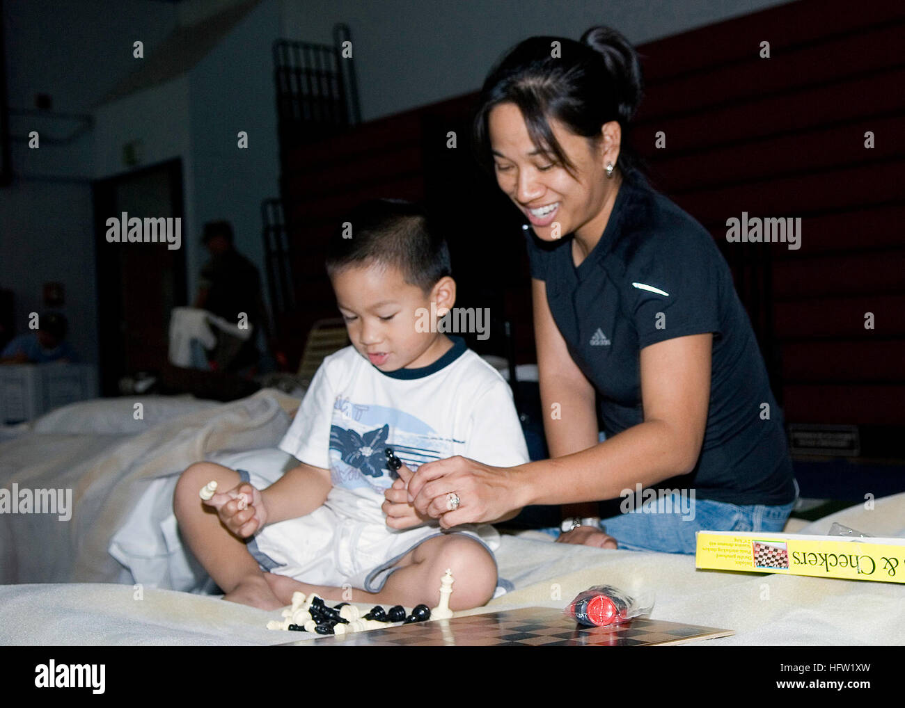 071023-N-4658G-033 SAN DIEGO (oct. 23, 2007) - La mère et le fils jouer aux échecs sur la base navale de San Diego Adm. James G. Prout Field House après l'évacuation de leur domicile à Otay Mesa pour éviter les incendies. Plus d'un quart de million de personnes ont été invités à quitter leurs foyers dans le sud de la Californie que les incendies de soufflé par les vents du désert féroce s'est précipité sur le paysage avec une vitesse terrifiante, détruisant des centaines de structures, colmatage des autoroutes, l'envoi de la fumée et des cendres sur une large zone. Les nombreux incendies dans le comté de San Diego ne posent pas de menaces pour les installations de la Marine dans la région. La Marine travaille avec divers agence Banque D'Images