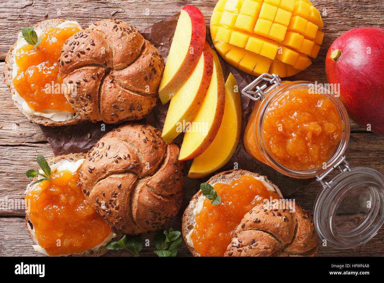 Petit-déjeuner : Sandwiches avec confiture et beurre de mangue douce close-up sur la table horizontale vue du dessus. Banque D'Images