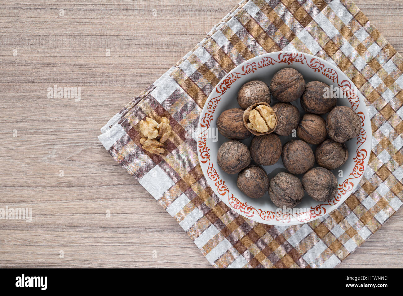 Ensemble les noix et cerneaux de noix en plaque blanche sur table avec nappe à carreaux Banque D'Images