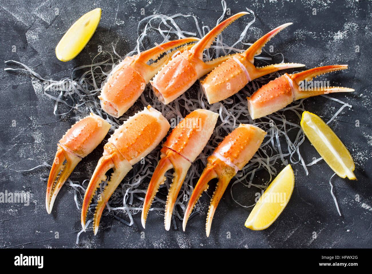 Pinces de crabe cuites avec du citron, sel de mer et poivre sur un fond en béton - concept de saine alimentation, régimes et la cuisson. Vue d'en haut. Banque D'Images