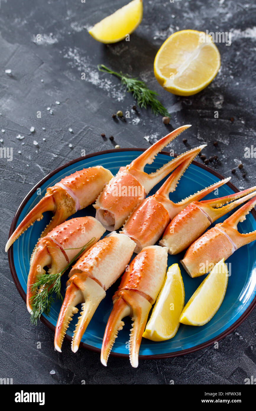 Pinces de crabe cuites avec du citron, sel de mer et poivre sur un fond — free download