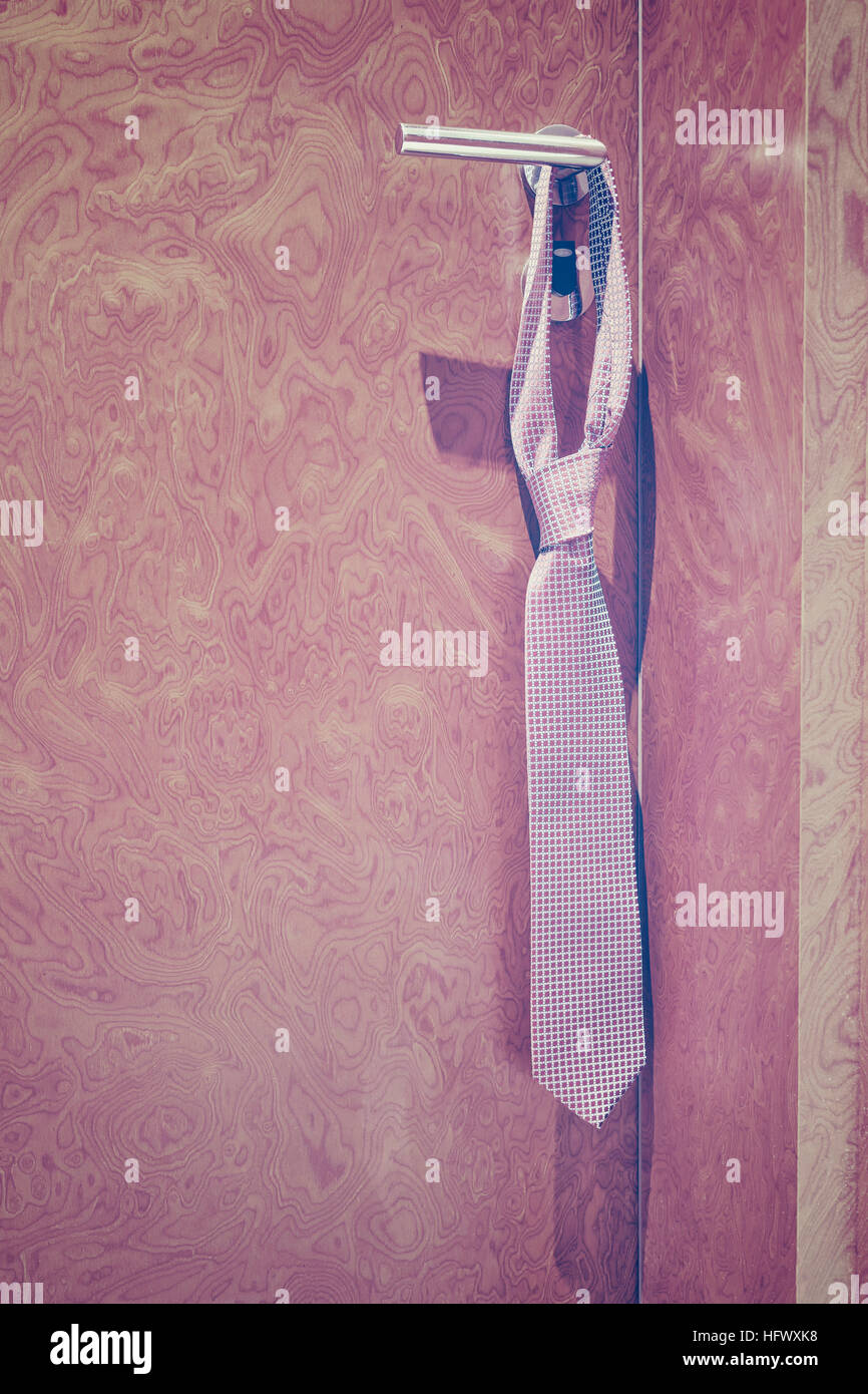 Tons Vintage tie accroché à une poignée de porte fermée de l'hôtel. Banque D'Images