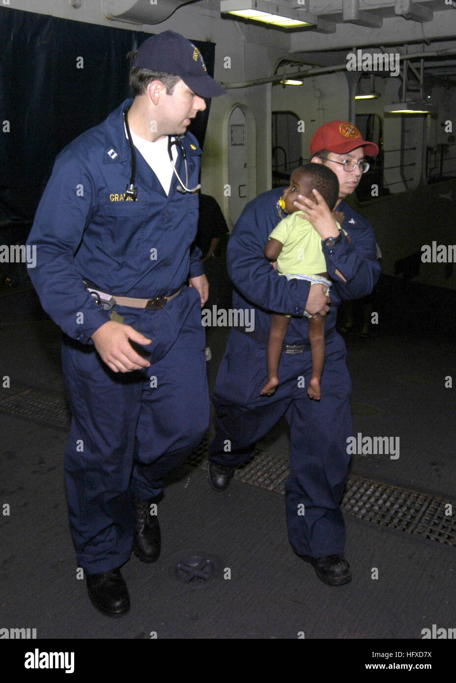 050908-N-8933S-001 New Orleans (sept. 8, 2005) Ð Le Lieutenant Scott Grabill, à gauche, et l'Hospital Corpsman 3rd Class Jose Rodriguez, droite, prendre un jeune bébé de recevoir un traitement médical à bord du navire d'assaut amphibie USS Iwo Jima (DG 7). Iwo Jima est en face de la jetée à la Nouvelle Orléans, l'aide à la force de l'ouragan Katrina relief s'efforce de mettre beaucoup de fournitures nécessaires et aider à la côte du golfe du Mexique. La participation de la marine dans les opérations d'aide humanitaire est menée par la Federal Emergency Management Agency (FEMA), en collaboration avec le ministère de la Défense. Photo de la Marine américaine Banque D'Images