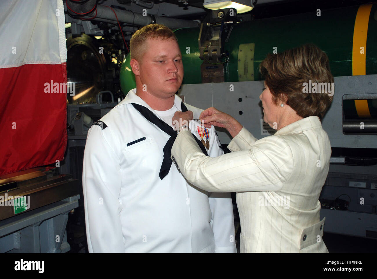 090731-N-3090M-060 Groton (Connecticut) (31 juillet 2009) l'ancienne Première dame Laura Bush et shipÕs parrainer les axes sous-marine terminal, ou ÒdolphinsÓ sur l'uniforme des machinistes Mate 3 classe Christopher Bragg au cours d'une visite de la sous-marin d'attaque USS Texas Virginia-Class (SSN 775). Bush a été un participant à la passation de commandement du Texas plus tard ce jour-là où le Cmdr. Robert Ronscka soulagé la Cmdr. James Gray comme commandant. (U.S. Photo par marine Spécialiste de la communication de masse 1re classe Steven Myers/libérés) US Navy 090731-N-3090M-060 et l'ancienne Première dame Laura Bush, marraine du navire, épingle la submar Banque D'Images