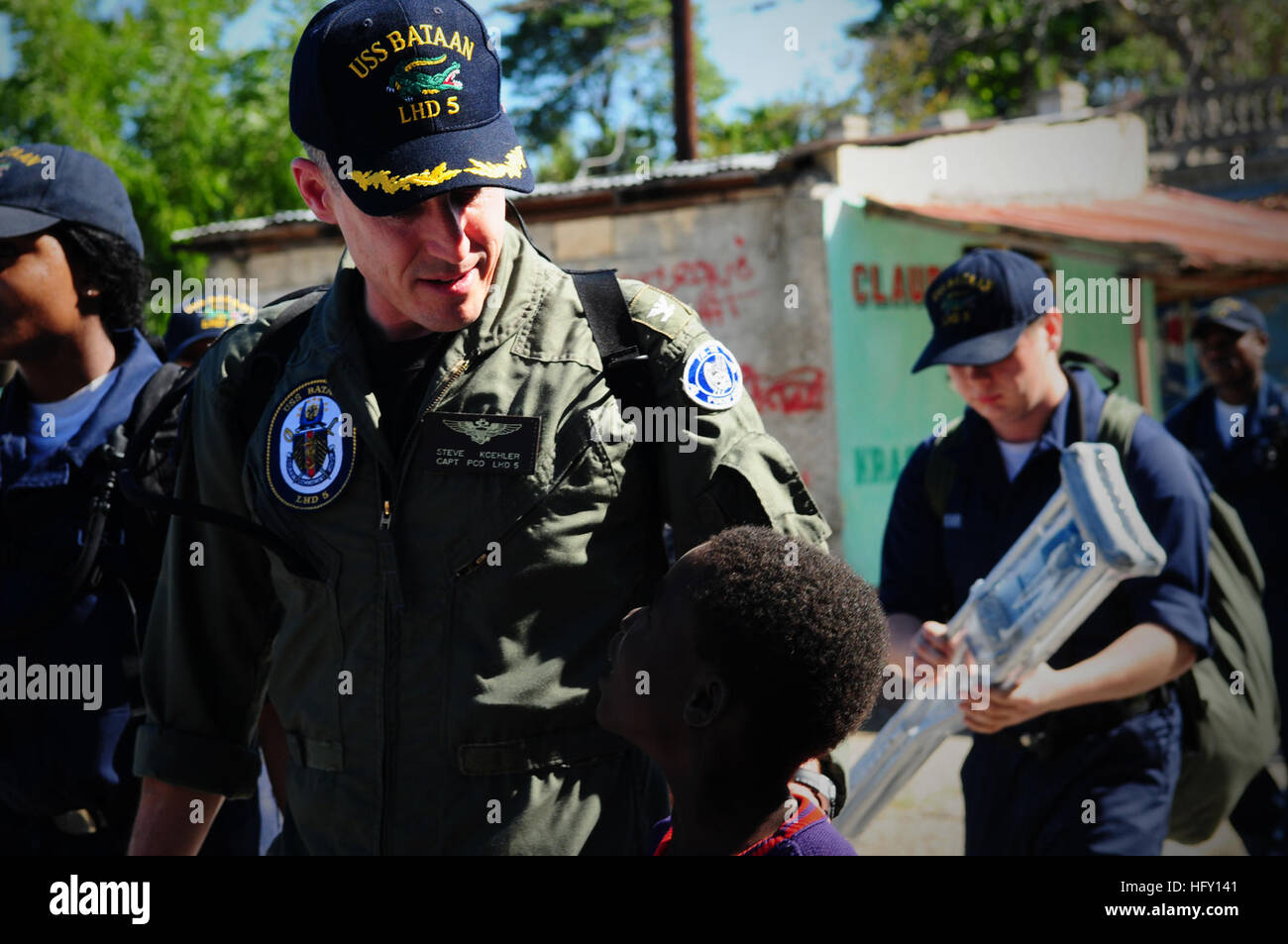 100128-N-7508R-071 BAIE DE GRAND GOAVE, Haïti (janvier 1985). 28, 2010) Le Capitaine Steve Koehler, futur commandant de navire d'assaut amphibie USS Bataan (DG 5) marche avec un enfant haïtien à Lifeline Christian Ministries Mission comme marins de la Bataan fournissent de l'aide aux Haïtiens déplacés par le séisme qui a dévasté Haïti récemment. Bataan, ainsi que des navires de débarquement quai amphibie USS Fort McHenry (LSD 43), USS Gunston Hall (LSD 44) et USS Carter Hall (LSD 50), est un soutien à l'opération réponse unifiée et offre des capacités de soutien militaire aux autorités civiles à l'hôtel Banque D'Images