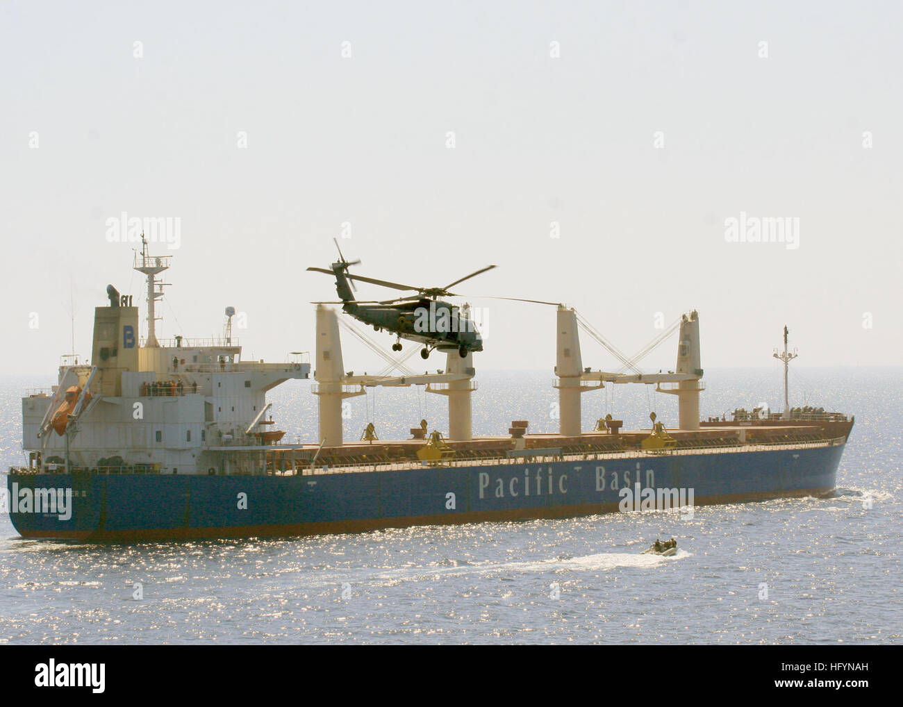 110324-N-BZ392-326 en mer d'Oman (25 mars 2011) Un SH-60B Sea Hawk hélicoptères anti-sous-marin de l'hélicoptère léger de l'Escadron (HSL) 48 embarquée à bord de l'USS croiseur lance-missiles le golfe de Leyte (CG 55) et d'un canot pneumatique à coque rigide du golfe de Leyte surveiller le navire marchand battant pavillon philippin M/V Commerçant Falcon II, qui avait envoyé un appel de détresse signalant en avait été arraisonné par des pirates. Hélicoptères de la Golfe de Leyte et USS Enterprise (CVN 65) ont répondu à l'appel et ont été en mesure d'distrupt l'attaque. Le Golfe de Leyte et de l'entreprise sont un soutien à l'opération Enduring Freedom et régionaux de mari Banque D'Images