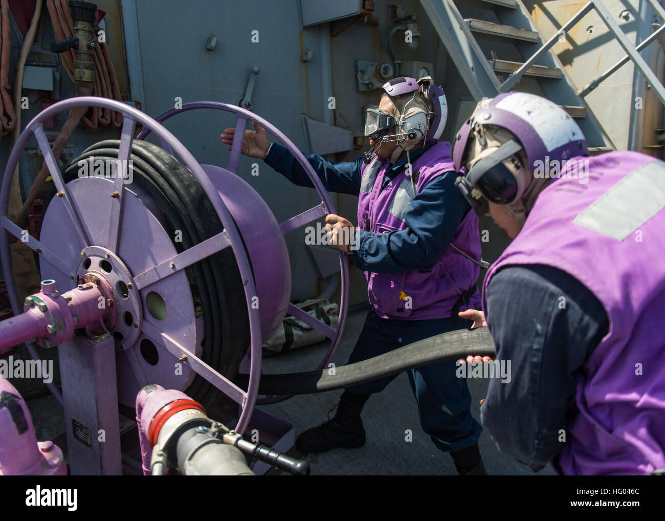 160910-N-GP524-229 Golfe Arabique (sept. 10, 2016) Technicien en système de turbine à gaz (mécanique) 3 Classe Rudolph McKenzie, centre, et technicien en système de turbine à gaz (mécanique) pompier Mario Orellana-rabatteur dans un tuyau de carburant après le ravitaillement à bord de l'hélicoptère opérations missiles USS Stout (DDG 55). Stout, déployés dans le cadre du groupe aéronaval d'Eisenhower, appuie les opérations de sécurité maritime et les efforts de coopération en matière de sécurité dans le théâtre dans la 5e flotte américaine zone d'opérations. (U.S. Photo par marine Spécialiste de la communication de masse de la classe de 3ème), Bill Dodge USS STOUT (DDG 55) DEPLOYM Banque D'Images