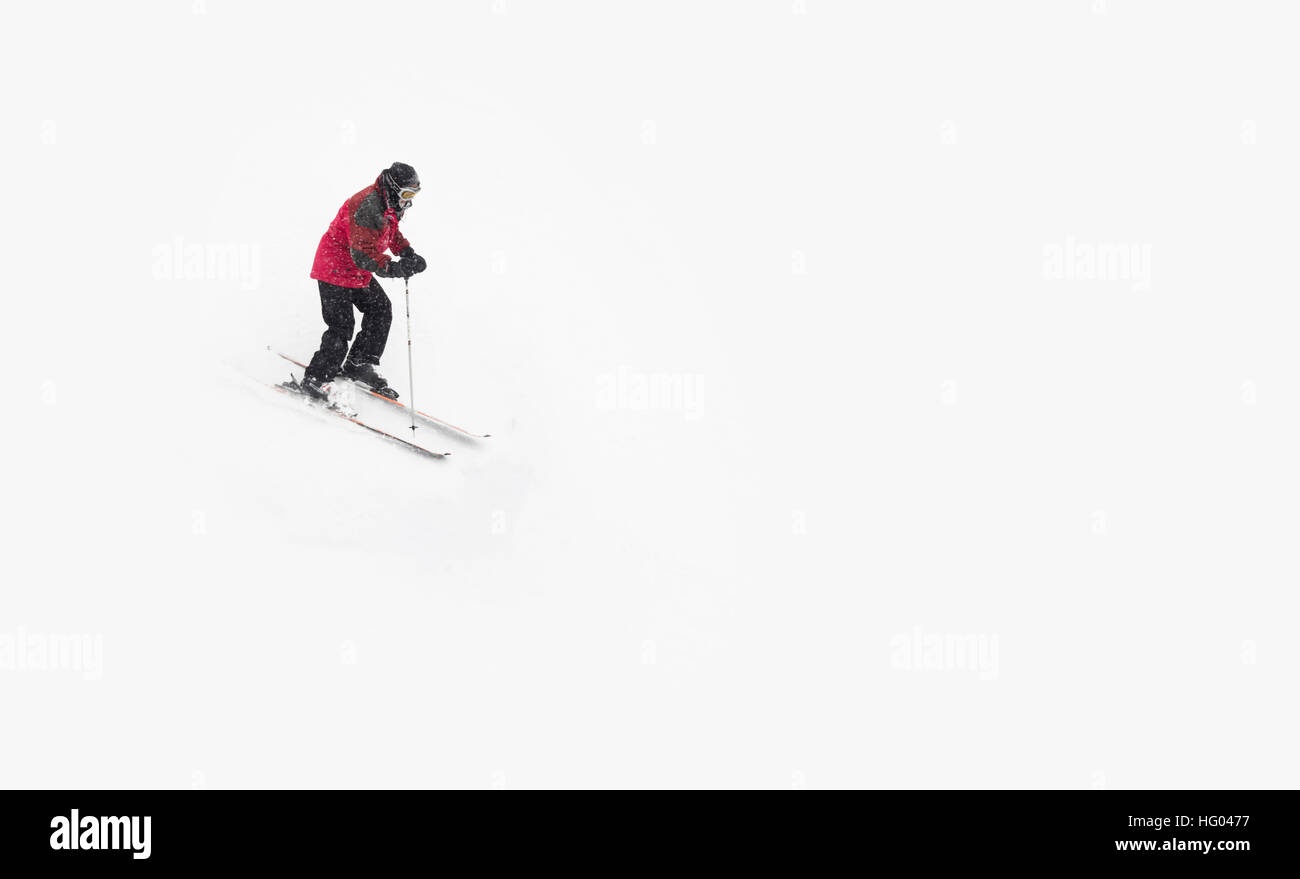 Ski alpin homme avec un manteau rouge. Banque D'Images