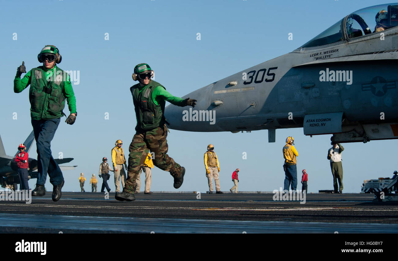 120101-N-OY799-119 en mer d'Oman (jan. 1, 2012) l'Aviation Boatswain's Mates (Matériel) 3 Classe Chord Deckert et Adam Fitzgerald effacer la zone de lancement qu'un F/A-18C Hornet de la grève de Warhawks Fighter Squadron (VFA) 97 se prépare à lancer sur le poste de pilotage de la classe Nimitz porte-avions USS JOHN C. STENNIS (CVN 74). John C. Stennis est déployé sur le 5e Flotte des États-Unis zone de responsabilité des opérations de sécurité maritime et missions d'appui dans le cadre de l'opération Enduring Freedom. (U.S. Photo par marine Spécialiste de la communication de masse de la classe 3e/44) Kenneth parution nous Nav Banque D'Images