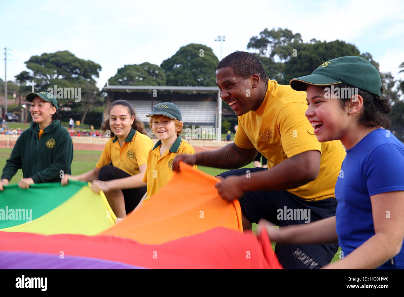 Technicien de systèmes d'information de la Marine américaine 2e classe Jeremy Franklin, deuxième à partir de la droite, affecté à la commande amphibie USS Blue Ridge (CAC 19), joue un jeu avec des enfants australiens lors d'un événement de service communautaire avec Lugarno Public School à Sydney, Australie, le 18 juillet 2013. (U.S. Photo par marine Spécialiste de la communication de masse 3 Classe Jared Harral/relâché), USS Blue Ridge operations 130718-N-NN332-161 Banque D'Images