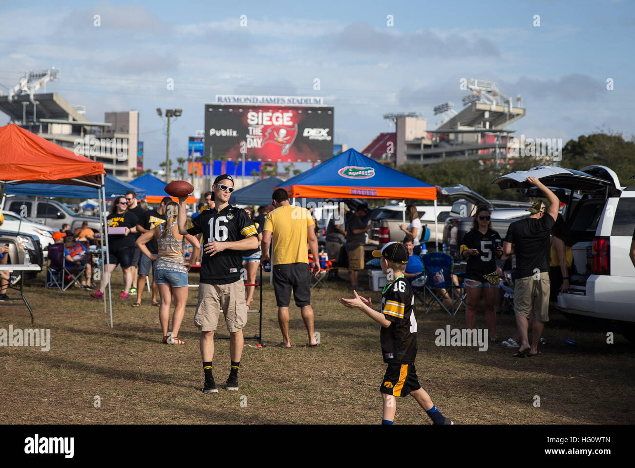 En Floride, aux États-Unis. 2 Jan, 2017. LOREN ELLIOTT | fois .Troy Shoen jette un football pour fils Dillon Shoen, 8, tandis que le talonnage avant l'Outback Bowl entre les Gators de la Floride et de l'Iowa Hawkeyes chez Raymond James Stadium de Tampa, en Floride, le lundi, Janvier 2, 2017. La famille Shoen vit à Huxley, Iowa, et conduit 20 heures pour venir à l'Outback Bowl. © Loren Elliott/Tampa Bay Times/ZUMA/Alamy Fil Live News Banque D'Images