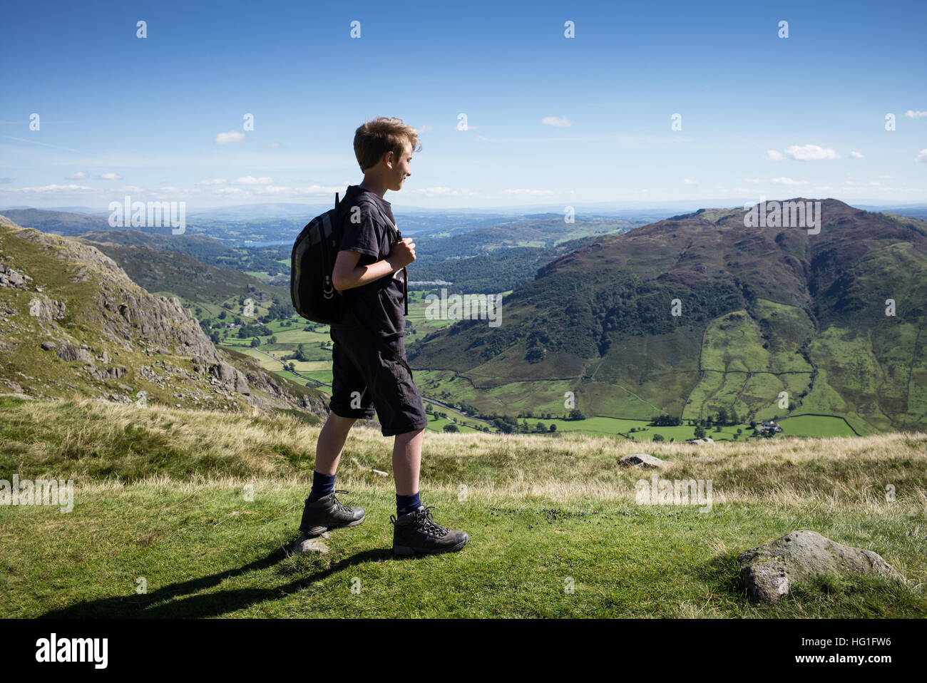 Un jeune randonneur dans le Lake District à la recherche dans la distance de Stickle Tarn. Banque D'Images