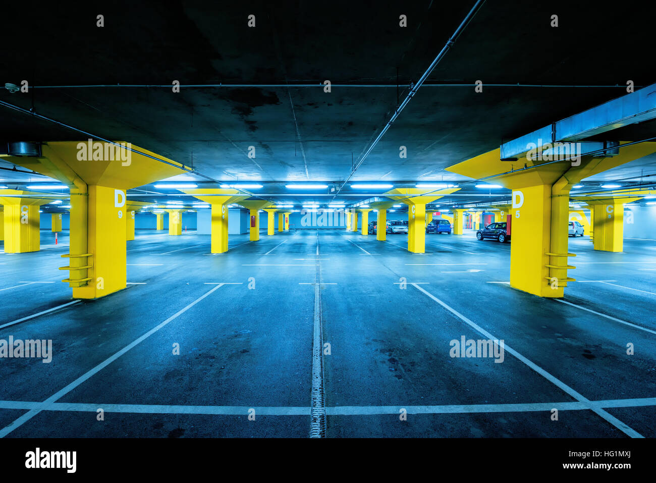 Parking souterrain avec peu de voitures et des espaces vides pour plus de véhicules, l'exploration urbaine et la géométrie dans l'architecture Banque D'Images