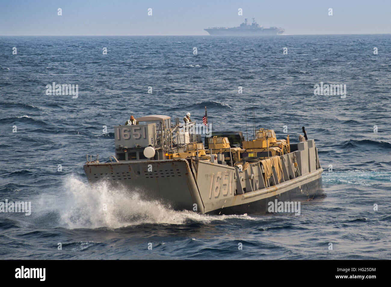 150315-N-NT265-007 est de la mer de Chine (15 mars 2015) - Un utilitaire de débarquement (LCU), affectés à la plage de la Marine (NBU) 7, se déplace dans la mer de Chine Orientale après le lancement du pont du coffre de l'île de Whidbey-class amphibious landing ship dock USS Ashland (LSD 48) et l'avant-déployé d'assaut amphibie USS Bonhomme Richard (DG 6) cuit à l'horizon. Ashland est une partie du Bonhomme Richard Groupe amphibie (ARG) et, de concert avec l'entrepris 31e Marine Expeditionary Unit, est actuellement à un exercice de certification (CERTEX). (U.S. Photo de la marine par la communication de masse Spe Banque D'Images