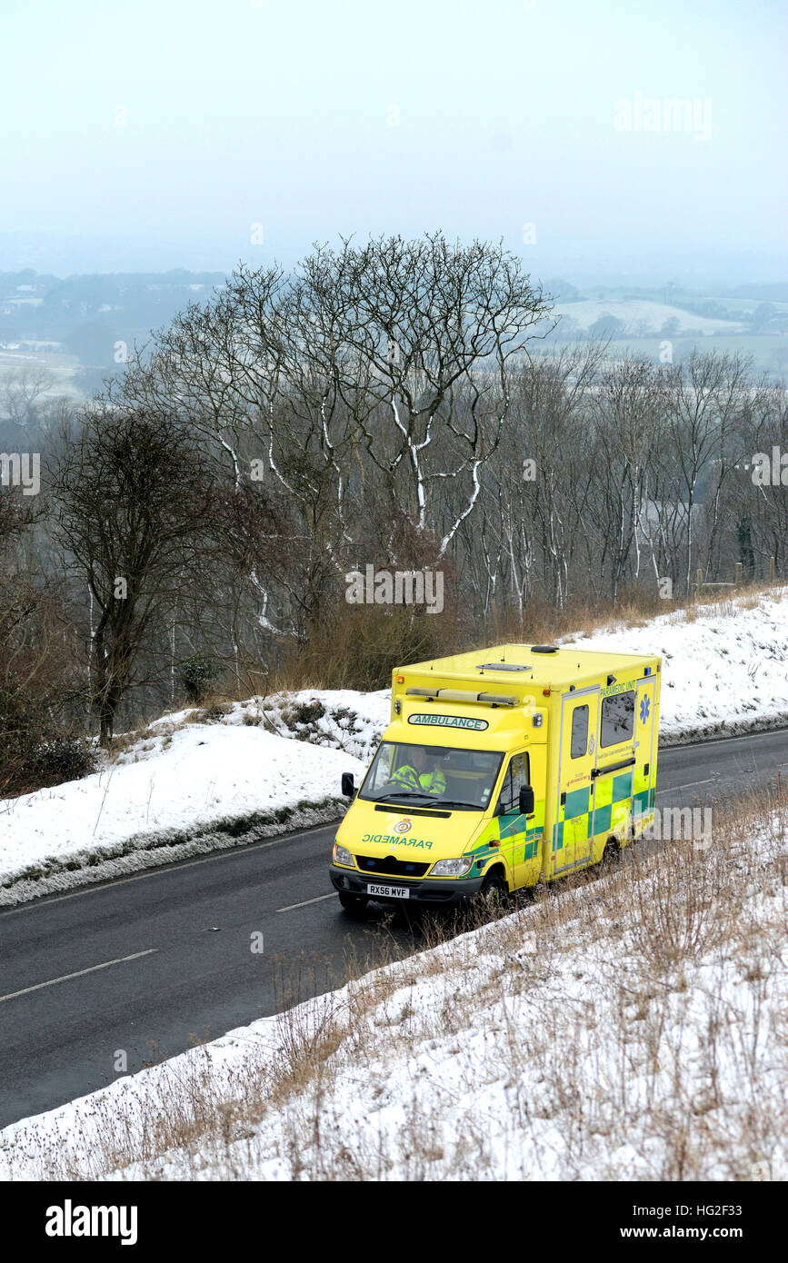 Ambulance sur une route de campagne entouré par la neige en hiver. Banque D'Images