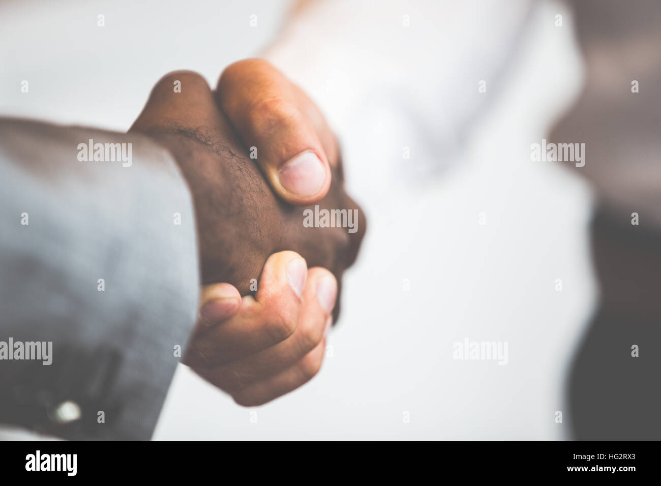 Poignée de main entre un homme de race blanche et de l'Afrique Banque D'Images