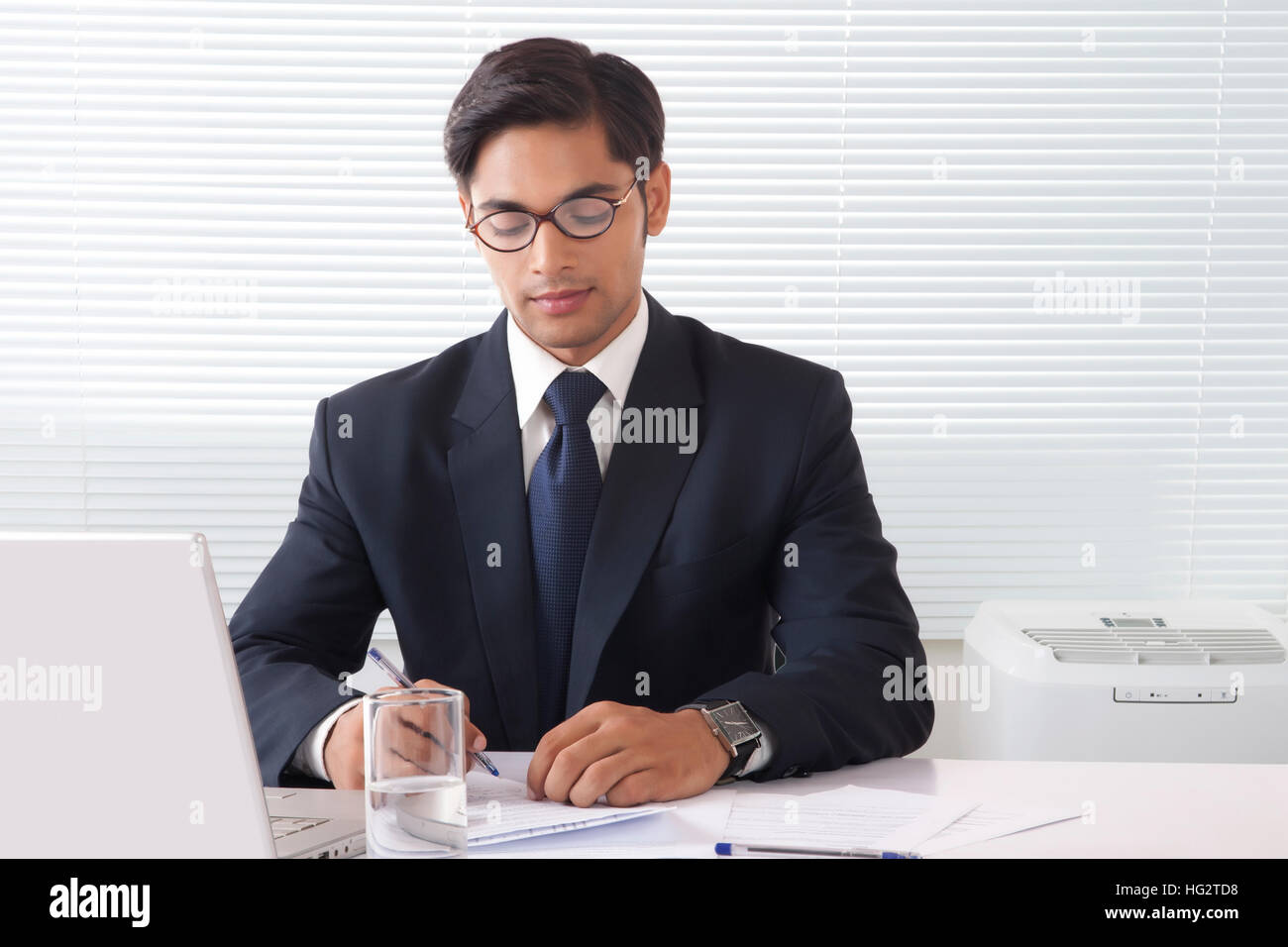 Jeune homme professionnel prise de notes à l'office de bureau avec ordinateur portable en face Banque D'Images