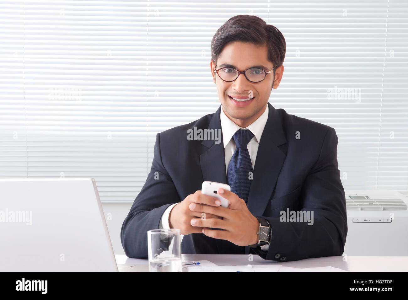 Heureux à la jeune homme professionnel l'exploitation de son téléphone mobile à Office 24 Banque D'Images