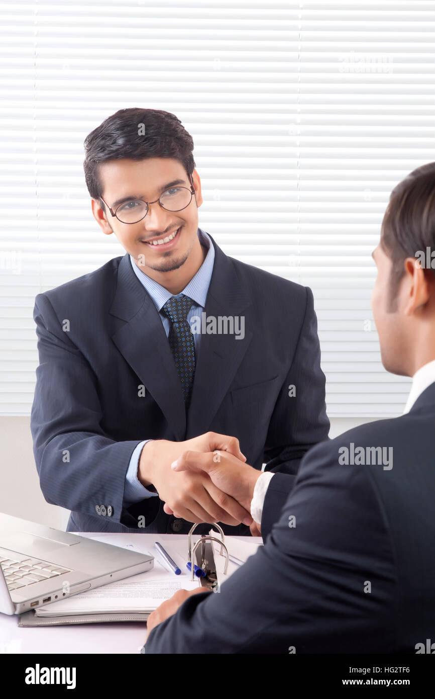 Deux jeunes hommes professionnels shaking hands with smile en cabine bureau Banque D'Images