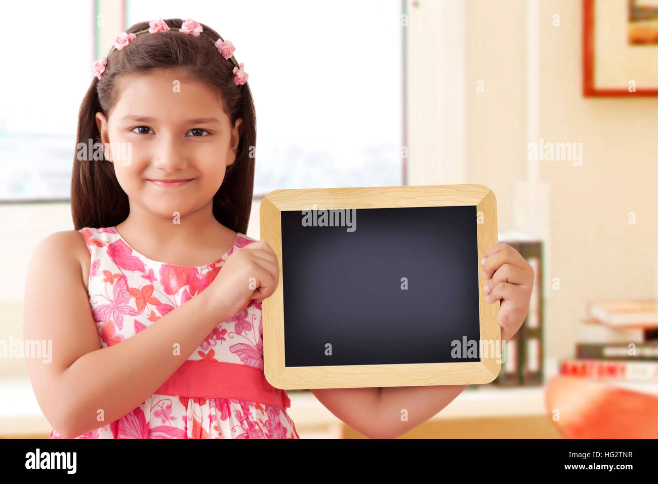 Girl smiling and holding slate Banque D'Images