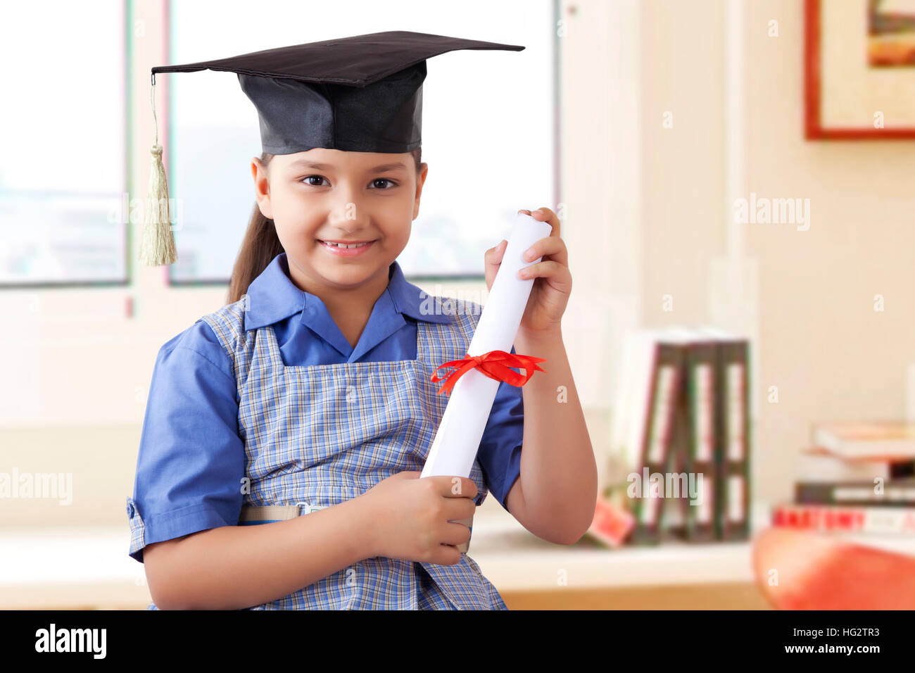 Girl wearing graduation cap et holding diploma Banque D'Images