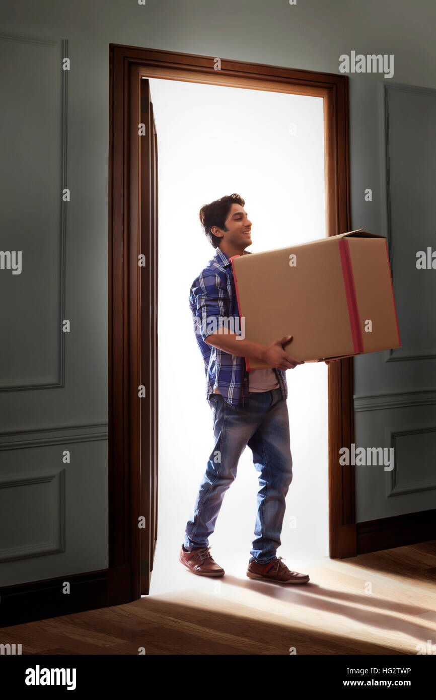 Young man carrying cardboard box Banque D'Images