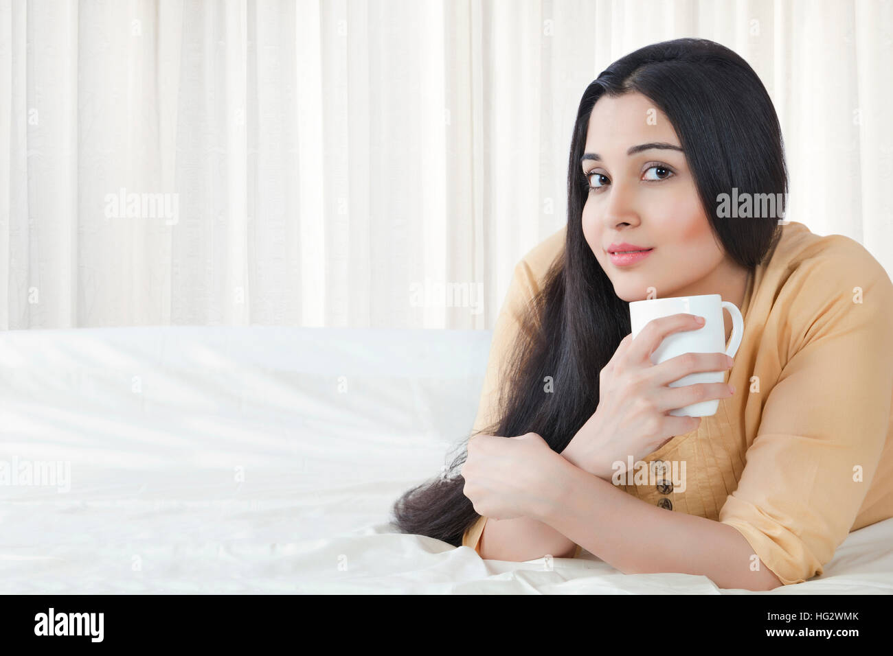 Belle jeune femme avec une tasse à café dans la chambre Banque D'Images