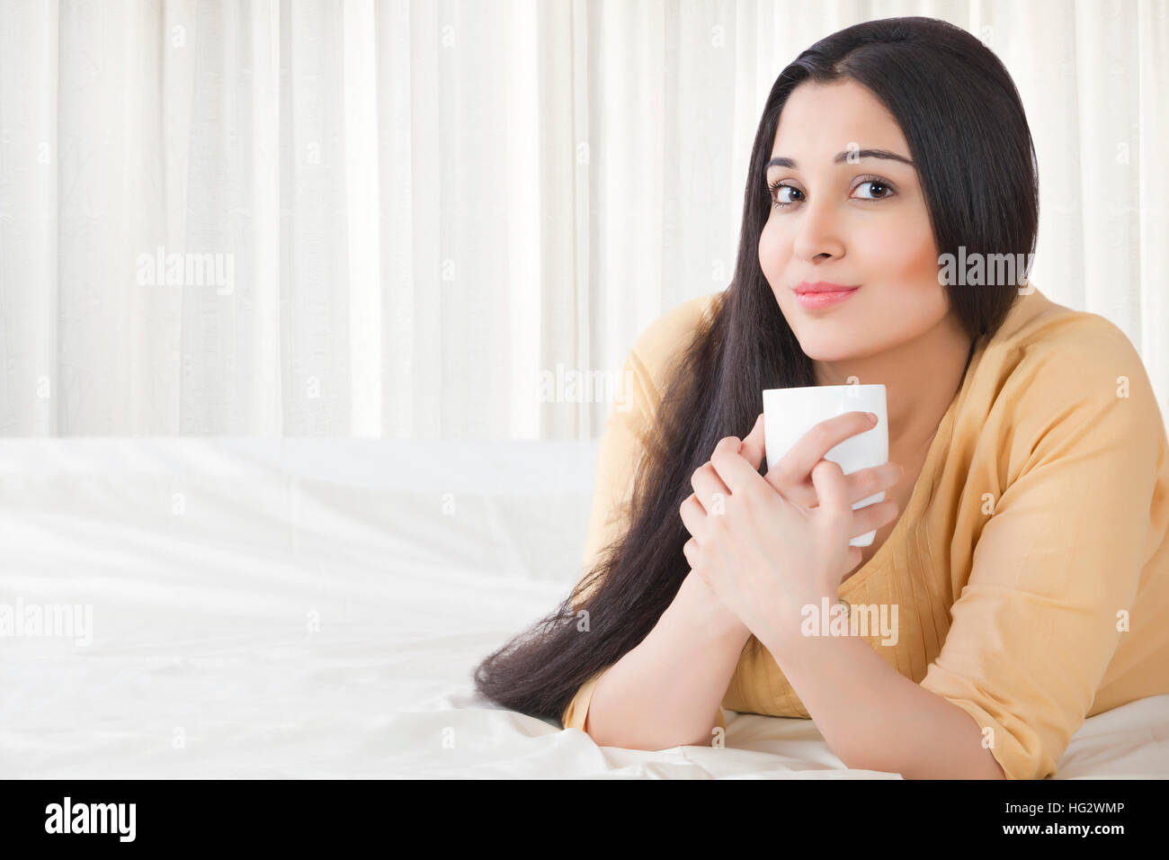Belle jeune femme avec une tasse à café dans la chambre Banque D'Images