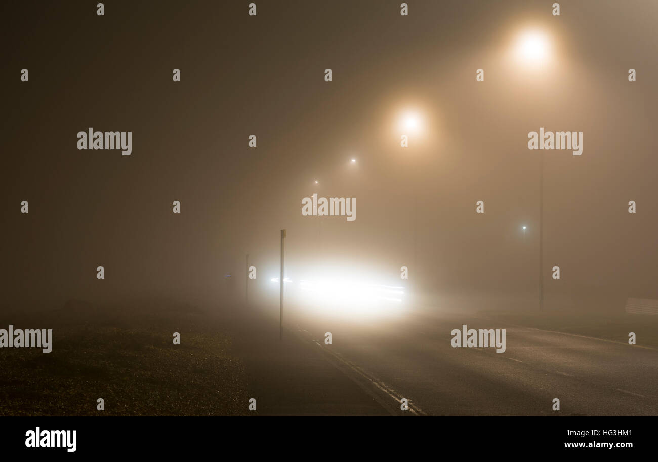 Route principale dans la nuit dans un épais brouillard, au Royaume-Uni. Temps brumeux. La brume du soir. Le brouillard pendant la nuit. Des conditions dangereuses. Conduire dans le brouillard. Banque D'Images