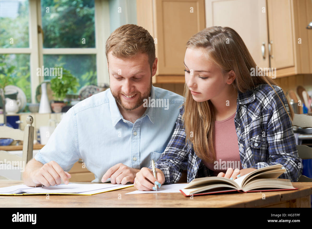 Accueil tuteur mâle Adolescente aidant avec des études Banque D'Images