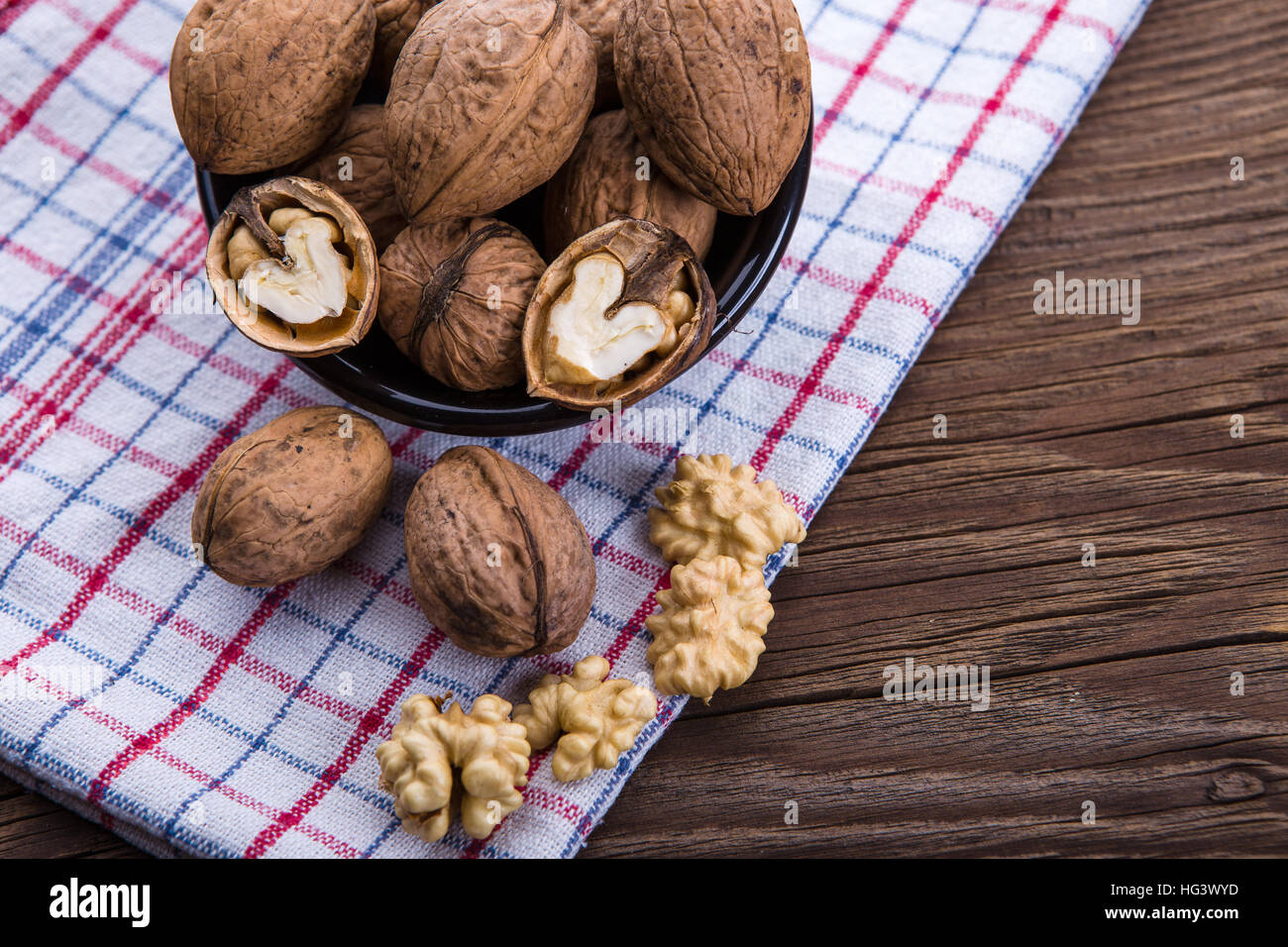 Les cerneaux de noix entiers et sur la vieille table de bois et torchon Banque D'Images