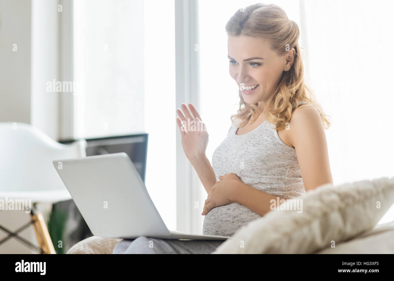 Woman conversation sur l'ordinateur portable dans la chambre Banque D'Images