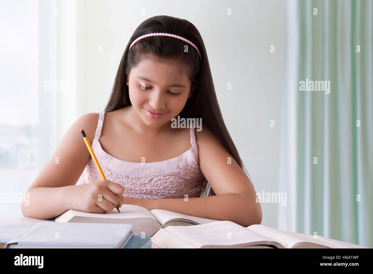 Portrait of cute girl doing homework Banque D'Images