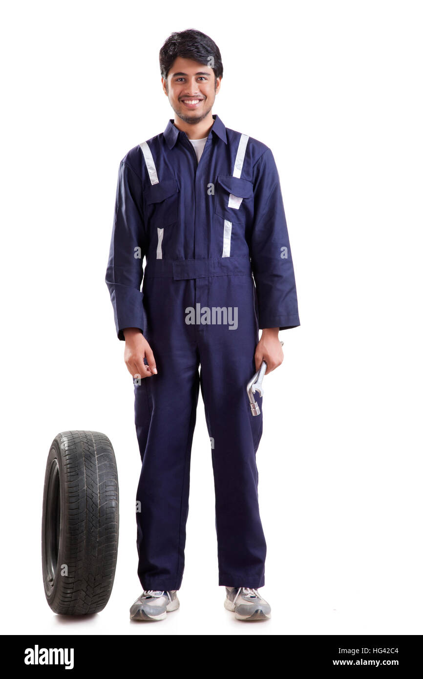 Portrait de mécanicien de voiture avec des pneus de rechange Banque D'Images