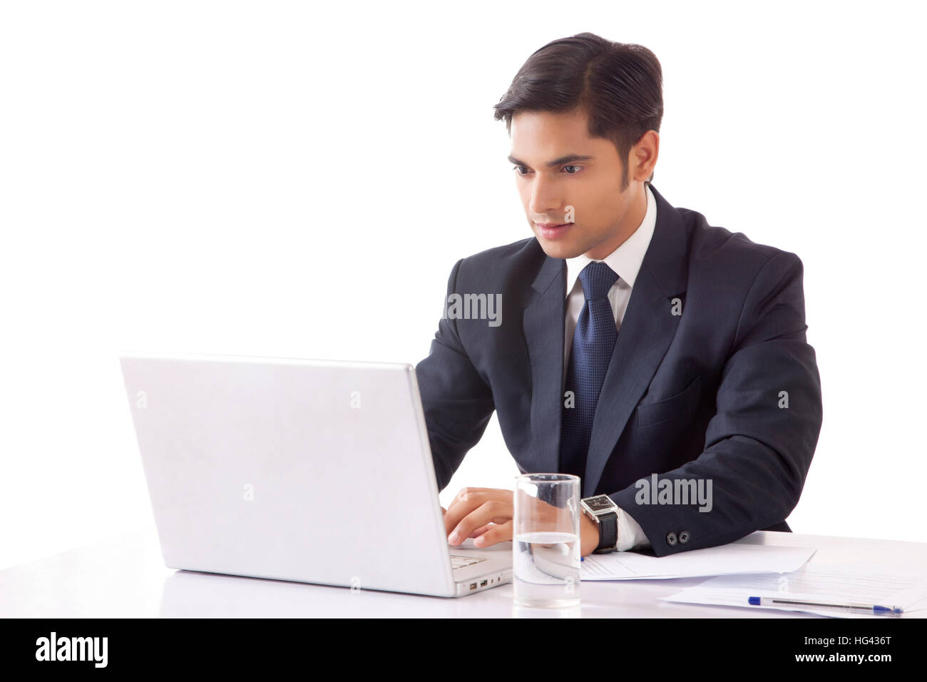 Young man working on laptop computer in office against white background Banque D'Images