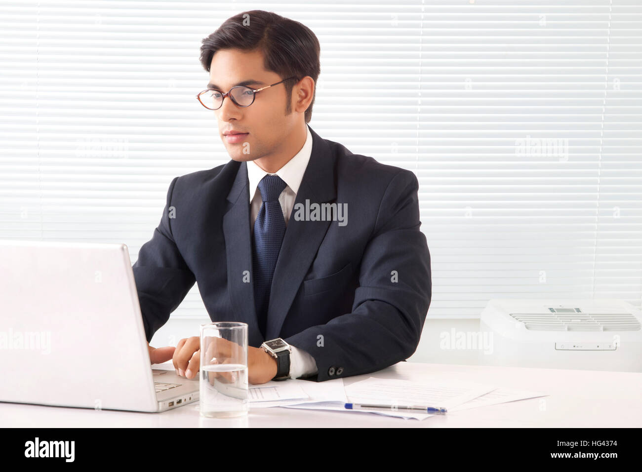 Jeune homme professionnel travaillant avec la concentration sur un ordinateur portable dans la salle de bureau Banque D'Images