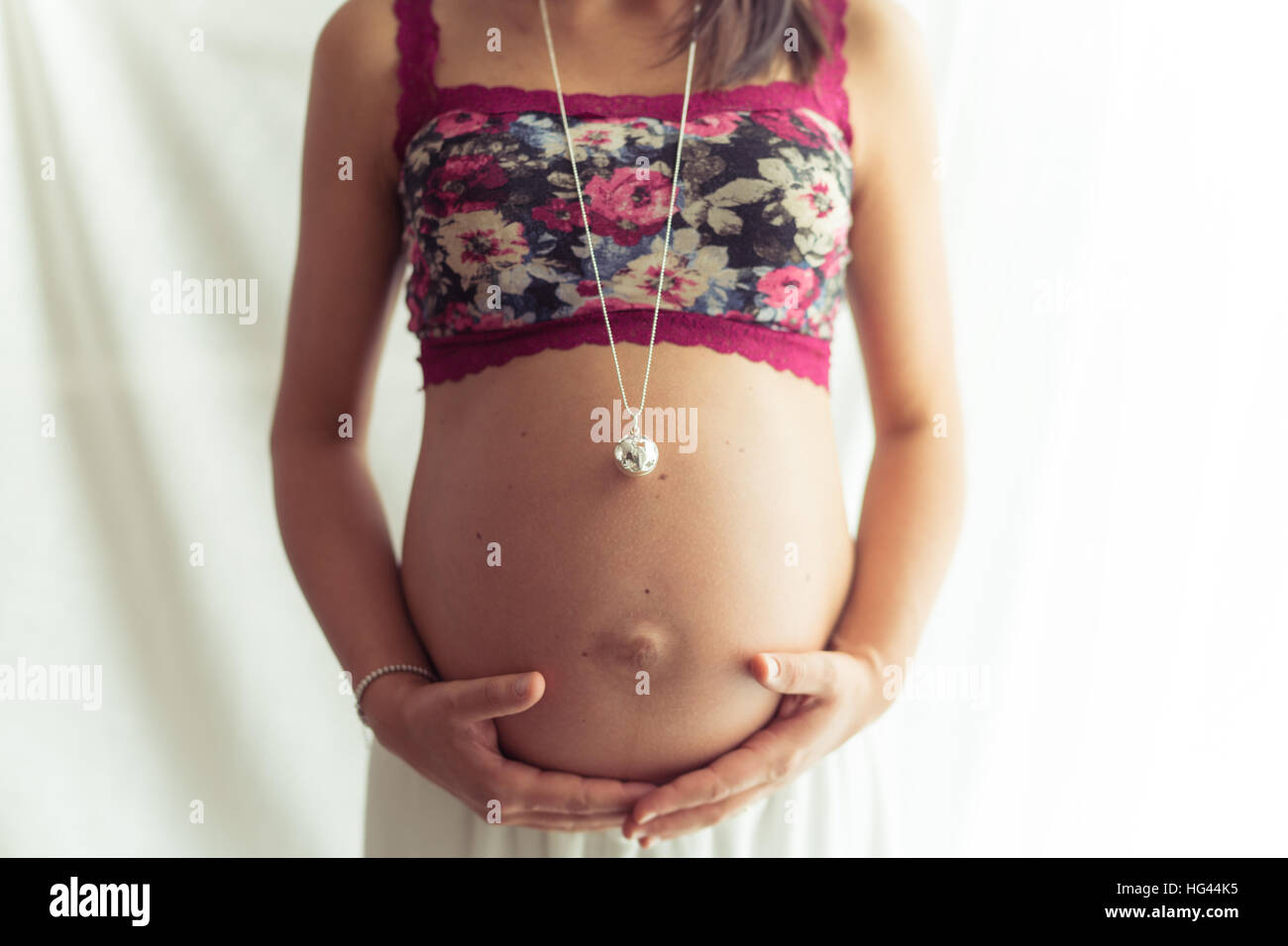 Femme enceinte avec haut fleur et Collier avec pendentif. Banque D'Images