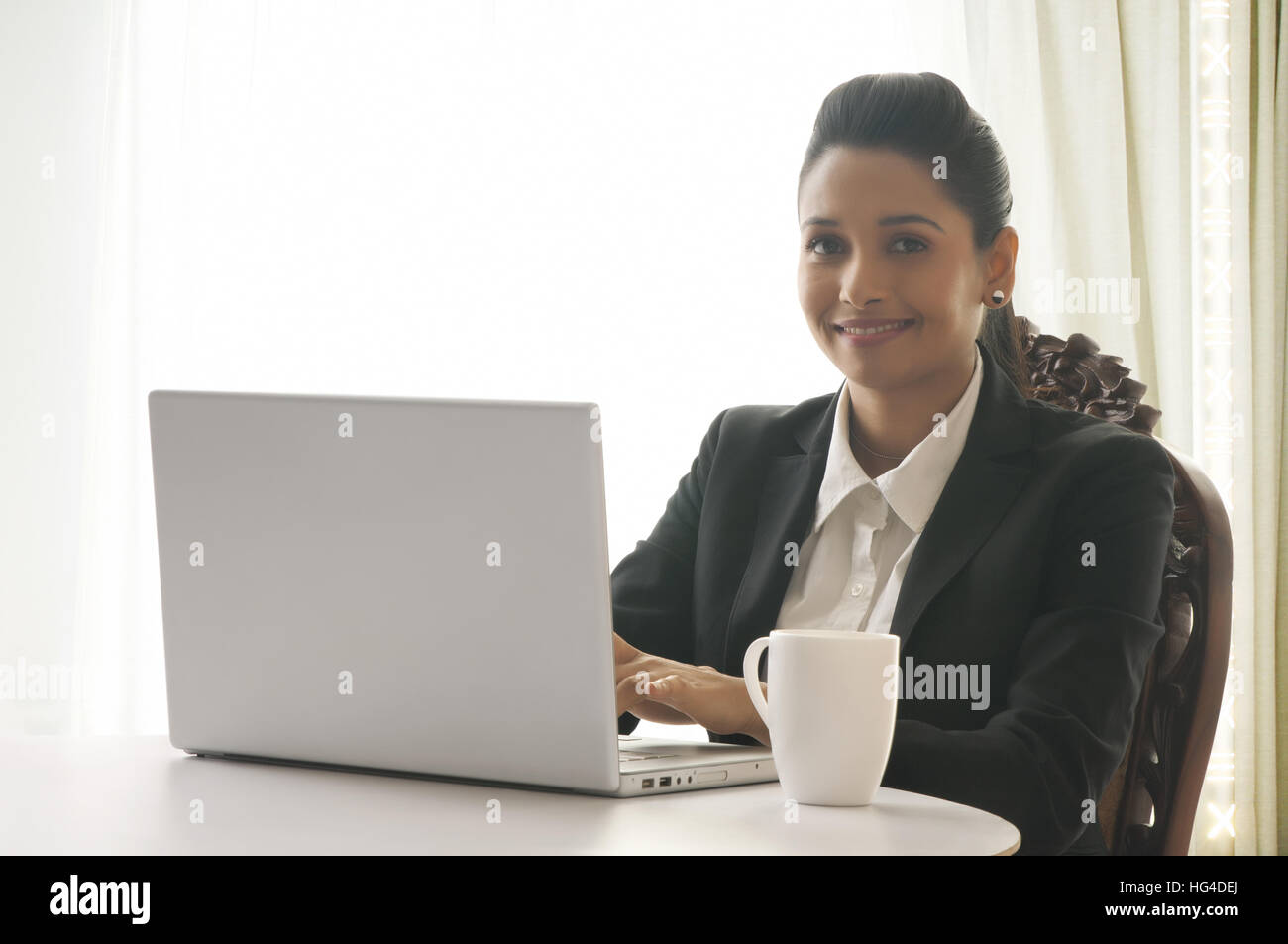 Business Woman wearing headphones and using laptop Banque D'Images
