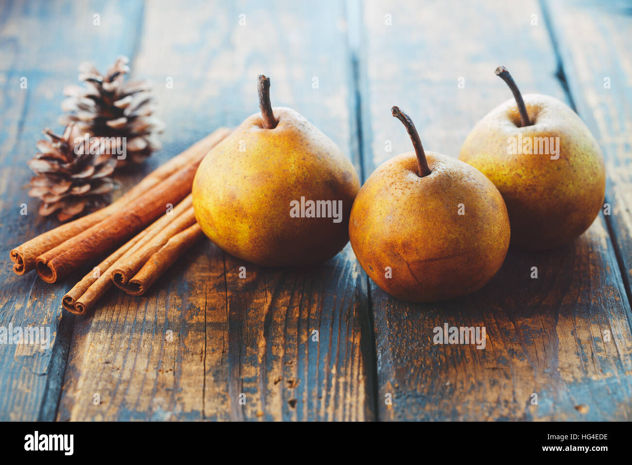 Poires biologiques avec des bâtons de cannelle sur une table en bois Banque D'Images