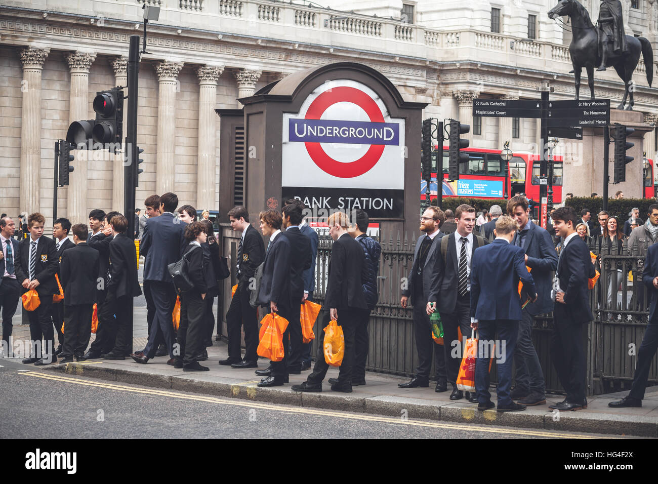 Londres, Groupe d'étudiants de St Paul's School avec orange sacs dans les  mains près de la station de métro Bank à Londres Photo Stock - Alamy