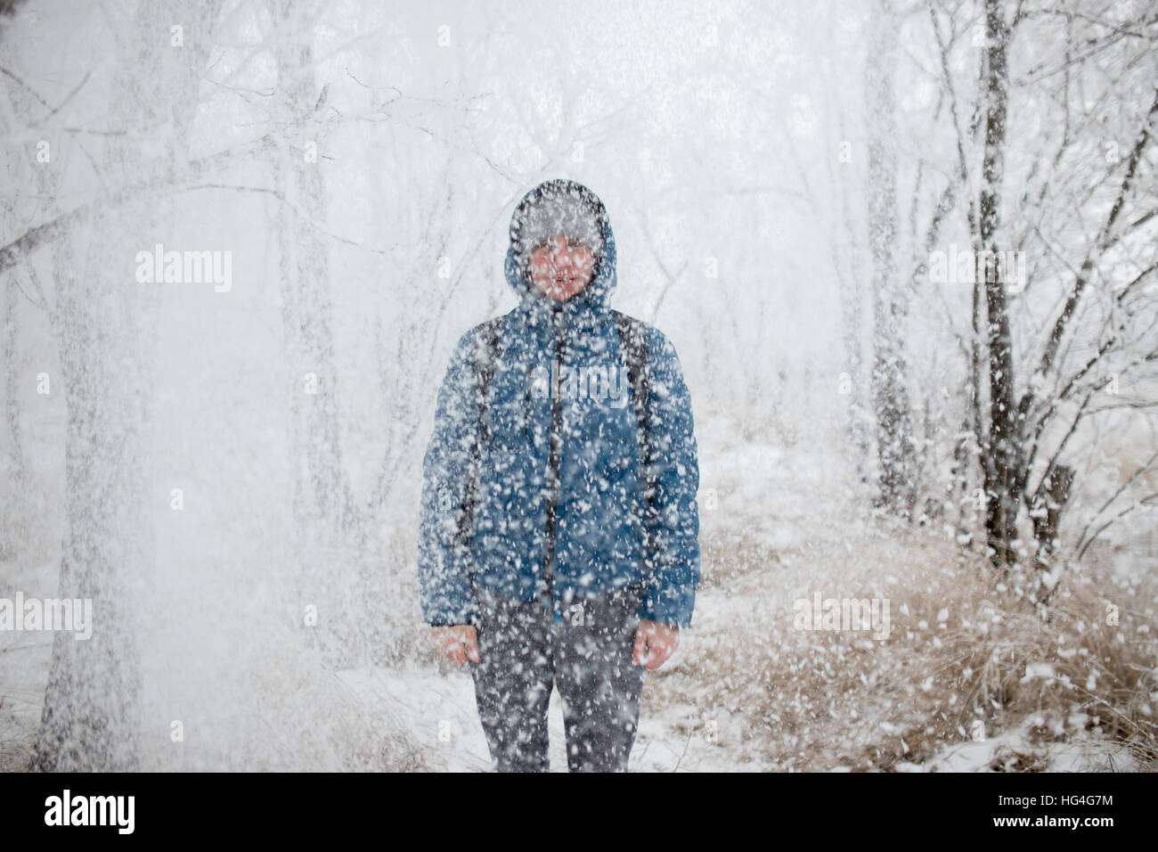 Beau jeune homme debout dans la neige sur fond de forêt enneigée. Banque D'Images Beau jeune homme debout dans la neige sur fond de forêt enneigée. Banque D'Images