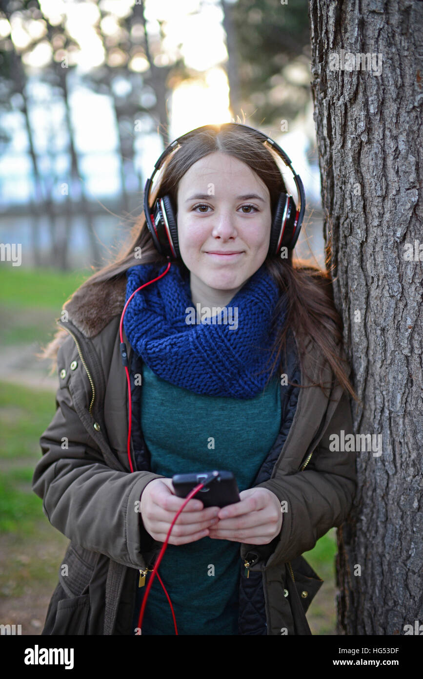 Adolescent j'écoute de la musique avec les écouteurs en park Banque D'Images