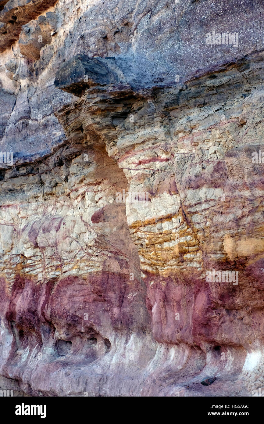 Un dyke magmatique des couches horizontales des bandes de couleur dans une roche sédimentaire à Wadi Ramon dans le bord extérieur du Grand Cratère Makhtesh Ramon un relief géologique considéré comme unique pour le désert du Néguev dans le sud d'Israël Banque D'Images