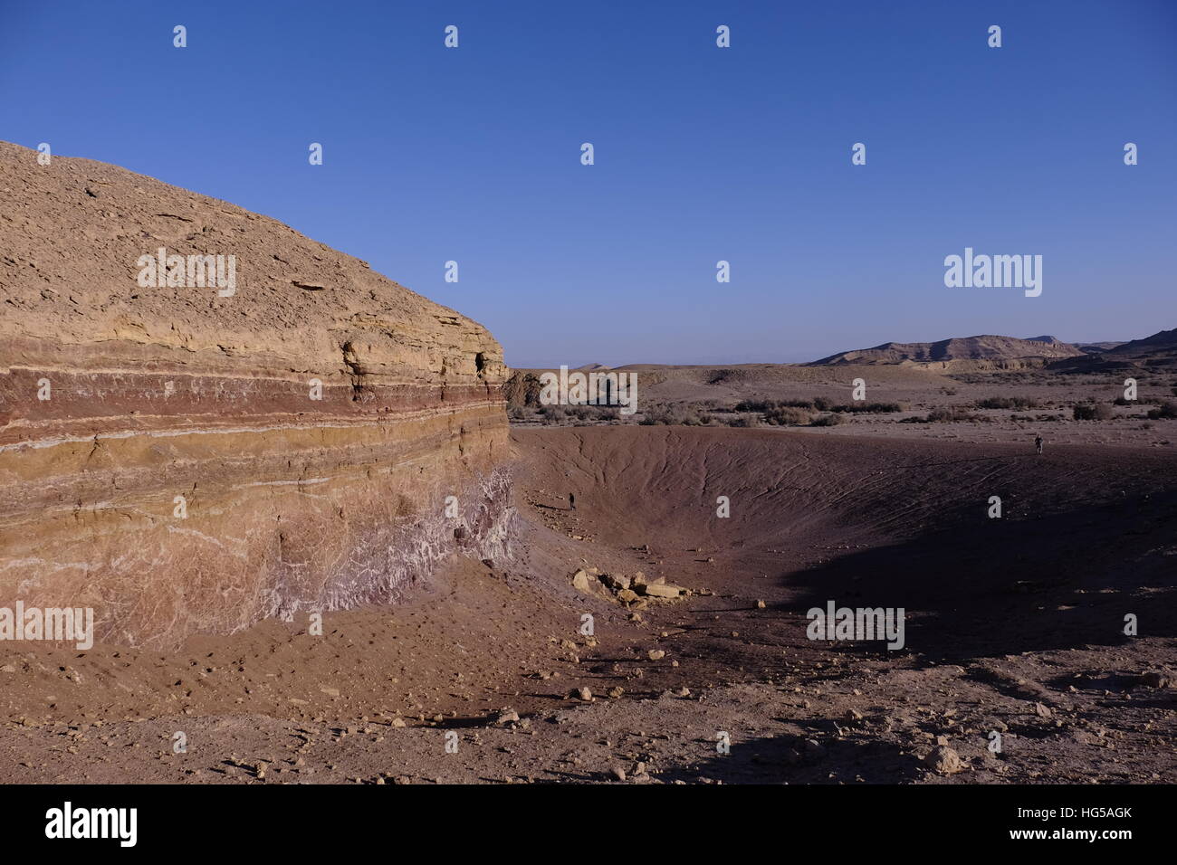 Un dyke magmatique des couches horizontales des bandes de couleur dans une roche sédimentaire à Beerot Khan au milieu du grand cratère Makhtesh Ramon un relief géologique considéré comme unique pour le désert du Néguev dans le sud d'Israël Banque D'Images